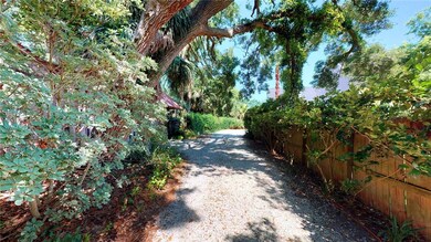Oak-draped white-gravel drive that leads 40 yards