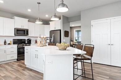 Another view of the large extended kitchen island.  Photo is of a previously built home, colors and finishes may vary.