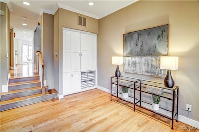 Living area with hardwood floors, crown molding an
