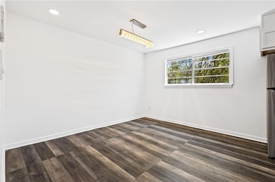 Unfurnished dining area featuring dark wood finished floors and recessed lighting