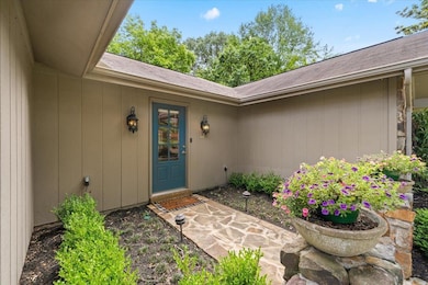 View of exterior entry featuring a shingled roof