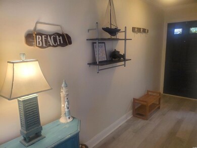 Entryway with wood finished floors and crown molding