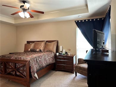 Bedroom featuring ornamental molding, a raised cei