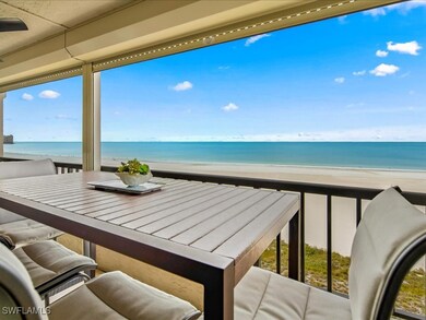 Balcony featuring view of water and beach