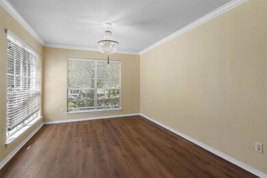 Unfurnished dining area with crown molding, dark wood-style floors, and a chandelier