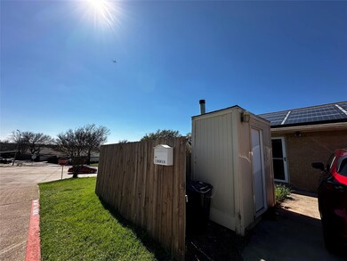 View of side of home featuring an outbuilding, roo
