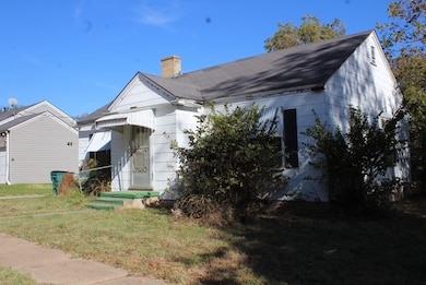 View of front of property with a front yard and a chimney