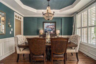 Dining area with a tray ceiling, a chandelier, a d