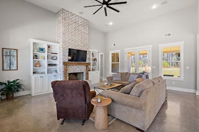 Living room featuring baseboards, a towering ceili