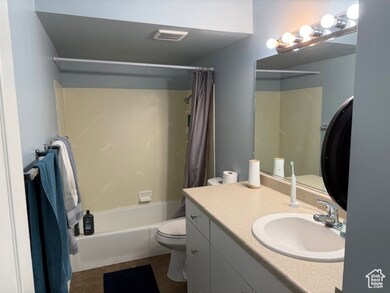 Full bath featuring shower / bathtub combination with curtain, vanity, and dark tile patterned floors