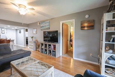 Living area featuring a ceiling fan, light wood-ty