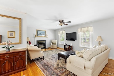 Living room with a ceiling fan, light wood-style f