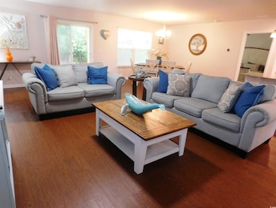Living room with wood finished floors and a chandelier