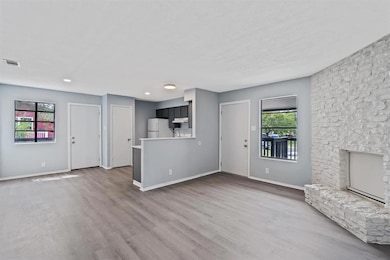 Unfurnished living room featuring baseboards, a f