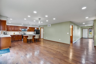 Open concept kitchen dining living area faced towards walk in pantry, mud room to garage and half bath also