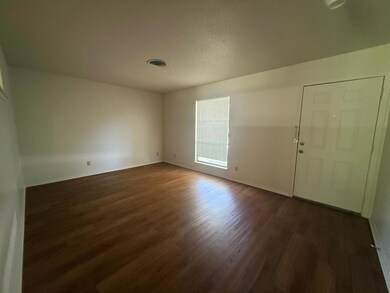 Empty room with dark wood finished floors and bas