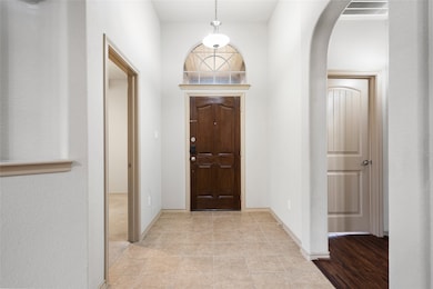 Foyer entrance with arched walkways and tile patterned floors