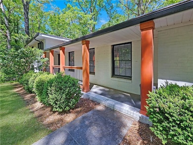 Doorway to property with a porch and brick siding