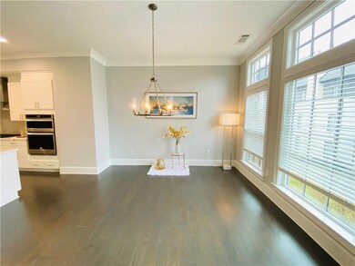 Unfurnished dining area featuring baseboards, ornamental molding, a chandelier, and dark wood finished floors