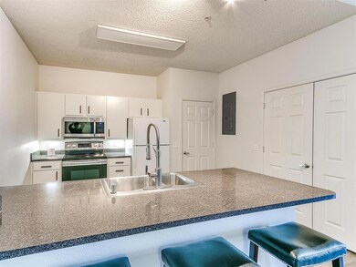 Kitchen with dark countertops, appliances with sta