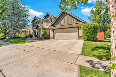 Craftsman-style house with board and batten siding, driveway, a front yard, and an attached garage