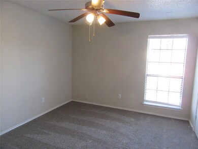 Unfurnished room featuring dark colored carpet and