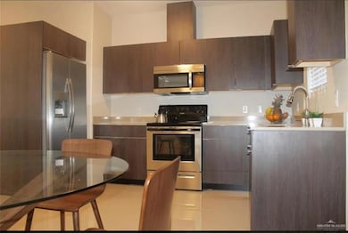 Kitchen featuring stainless steel appliances, light countertops, and modern cabinets
