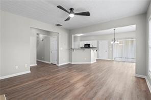 Unfurnished living room with baseboards, dark wood