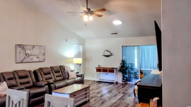 Living room with lofted ceiling, ceiling fan, wood finished floors, and recessed lighting