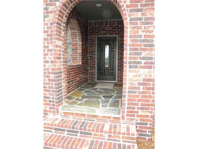 Exterior Front. Arched Covered Entry with Flagstone
