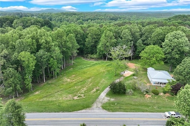 View of subject property featuring a wooded area and mountains