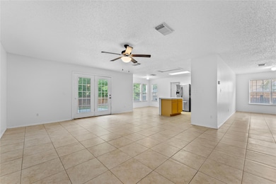 Unfurnished living room featuring a textured ceil
