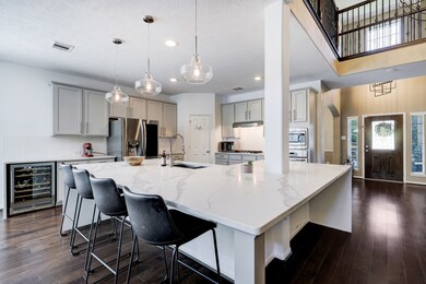 The fully updated kitchen features marble countertops, a wine fridge, and stainless appliances, with plenty of natural light and open concept for gathering.