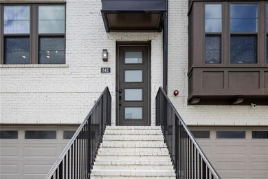 Doorway to property featuring brick siding and a garage