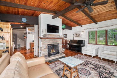 Living room featuring ceiling fan, a fireplace, wo
