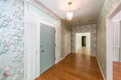 Spacious entry has wood flooring and coat closet.