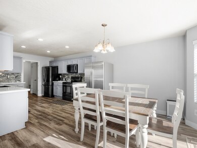 Dining space with dark wood-type flooring, a chandelier, and recessed lighting