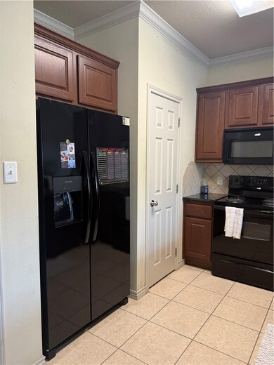 Kitchen featuring fridge, range, ornamental moldin