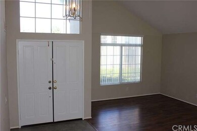 Entry leads into the large open living room. Wood 