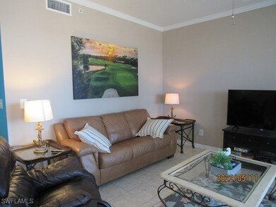 Tiled living area with crown molding and baseboard