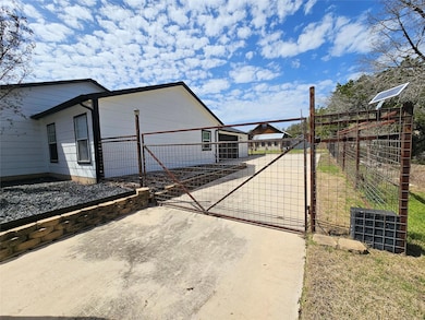 View of side of property featuring a gate, fence,