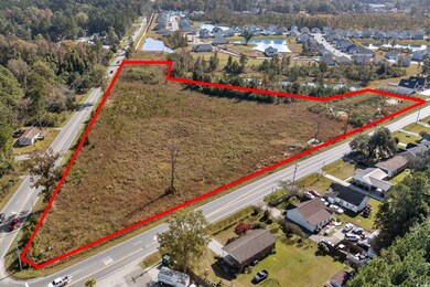 Aerial perspective of suburban area with property parcel outlined and a large body of water