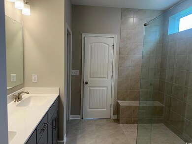Bathroom with tiled shower, tile patterned floorin