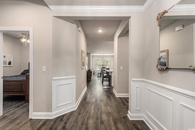 Corridor with dark wood-style flooring and baseboards