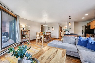 Living area featuring hardwood / wood-style floors, a chandelier, baseboard heating, and recessed lighting