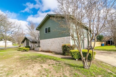 View of side of home with a lawn and stone siding