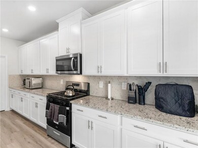 Kitchen with decorative backsplash, light hardwood