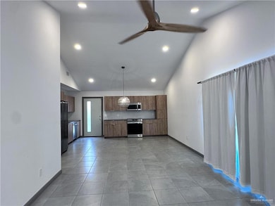 Kitchen featuring tasteful backsplash, stainless steel microwave, recessed lighting, and ceiling fan