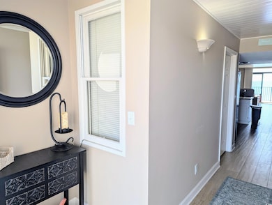 Corridor with baseboards, visible vents, and wood 