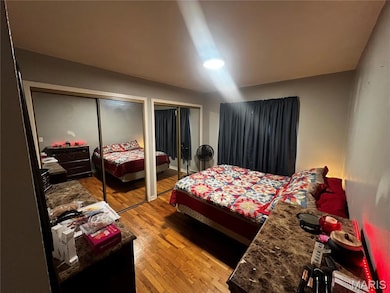 Bedroom with two closets and light wood-type flooring